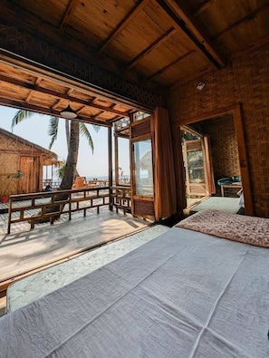 Una habitación con techo de madera, ventanas amplias y vistas a palmeras.