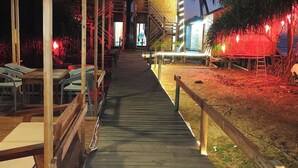 A wooden pathway leading to a building with a thatched roof and a staircase. - Sailor Eco Resort. Saint Martin (Chittagong Division)