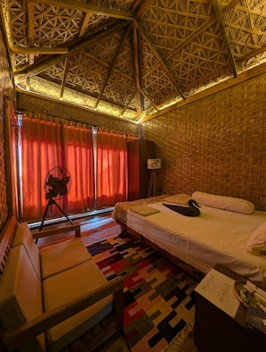 Ein Zimmer mit einem Bett, einem Schreibtisch, einem Stuhl, einer Lampe und einem fensterbelagten Fenster.