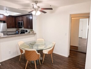 A compact kitchen with dark wood cabinets, a microwave, and a stainless steel refrigerator. - Cozy 1-bedroom apartment in lovely Los Angeles with AC and gym access (Los Angeles)