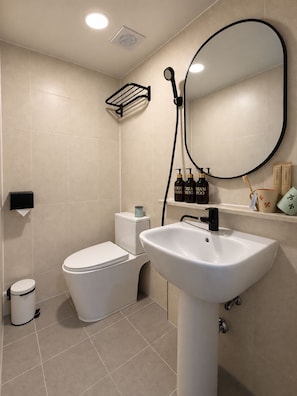 Une salle de bain moderne avec des toilettes, un lavabo et un miroir.