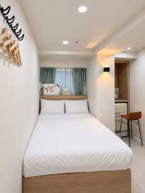 Une chambre bien rangée, avec un lit, un bureau et une chaise.