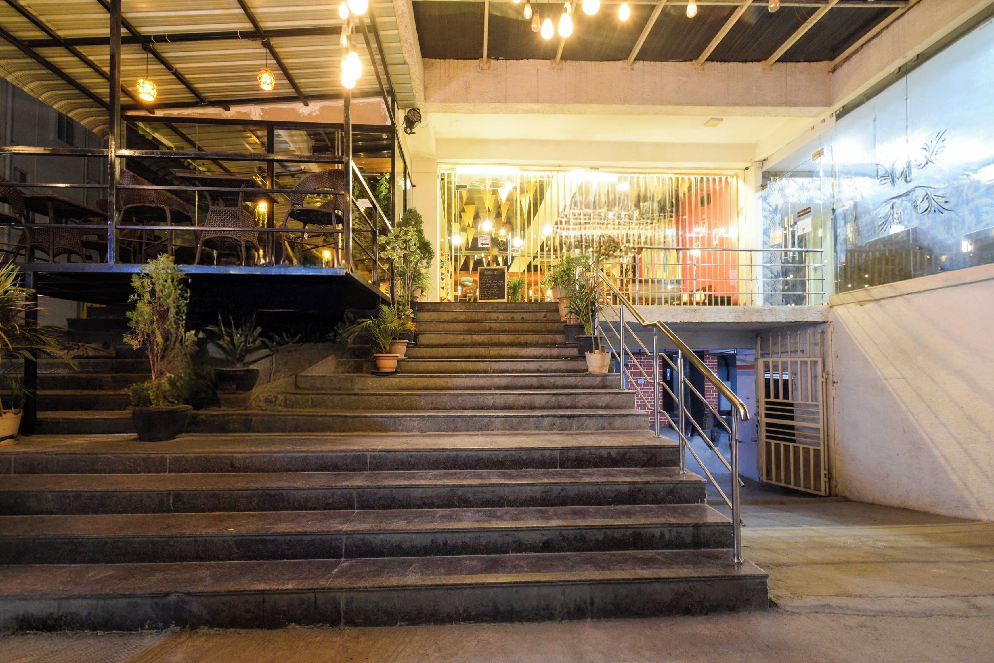 A staircase with metal railings leading to a brightly lit interior space.