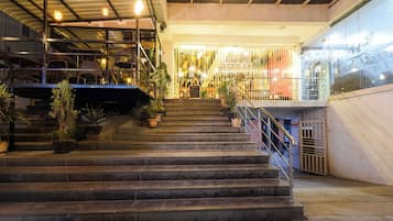 Una escalera con barandillas de metal que conduce a un espacio interior bien iluminado.