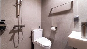Un baño moderno con inodoro, ducha y lavamanos.