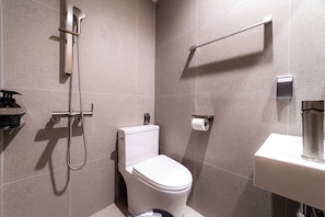Une salle de bain moderne équipée de toilettes, d’une douche et d’un lavabo.