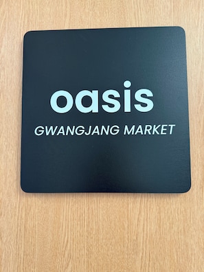 En svart fyrkant med texten ”oasis GWANGJANG MARKET” i vitt.