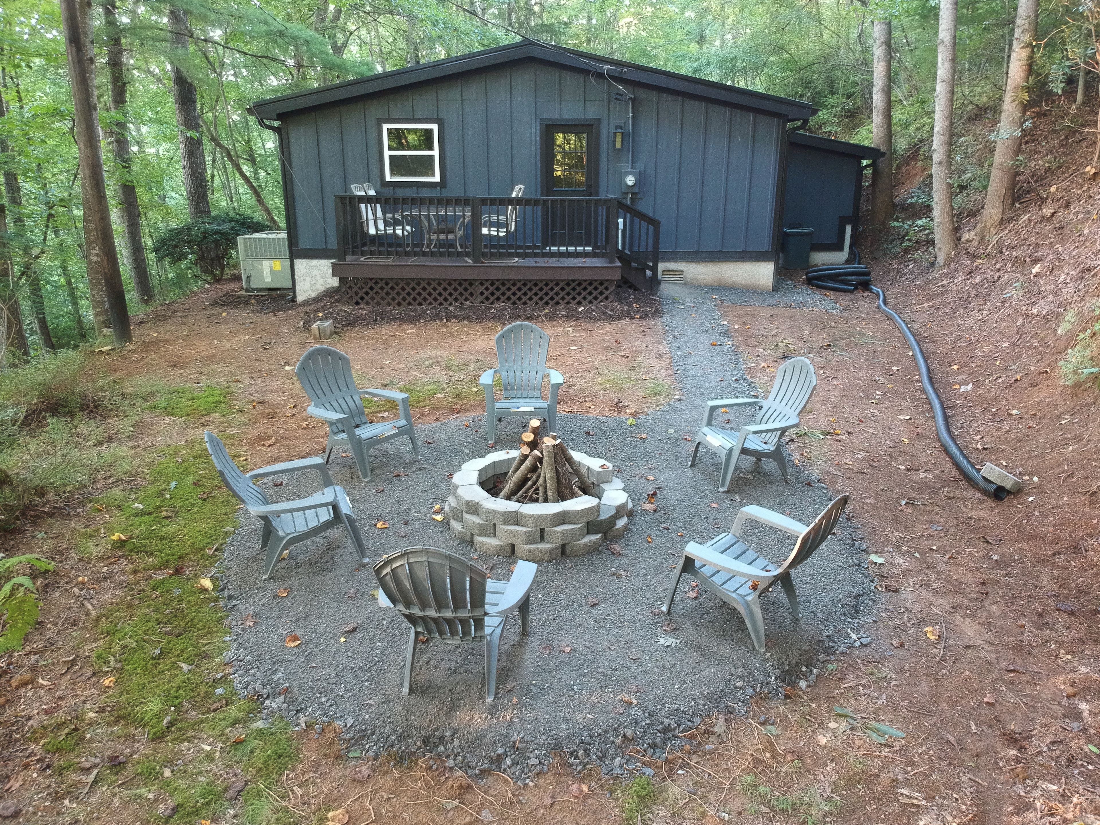 Une cabane dotée d’une terrasse, entourée d’espaces de détente en plein air et d’un foyer.