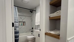 Ein modernes Badezimmer mit Badewanne, Toilette und Duschbereich.