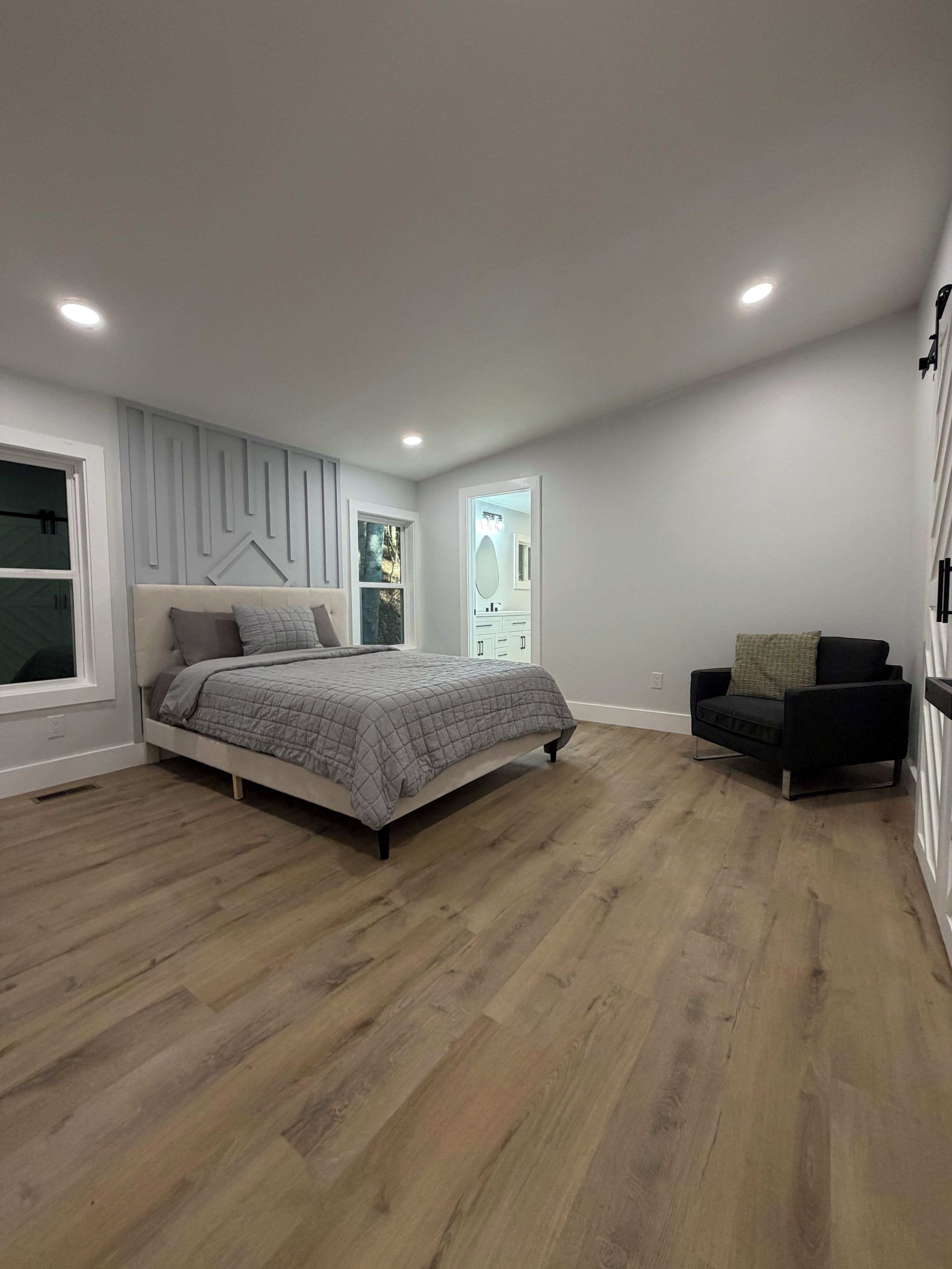 Une chambre à coucher avec un lit, une chaise et une fenêtre.