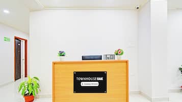 Una recepción con un letrero que dice 'Townhouse Oak' y 'Servicio de Empresa'.