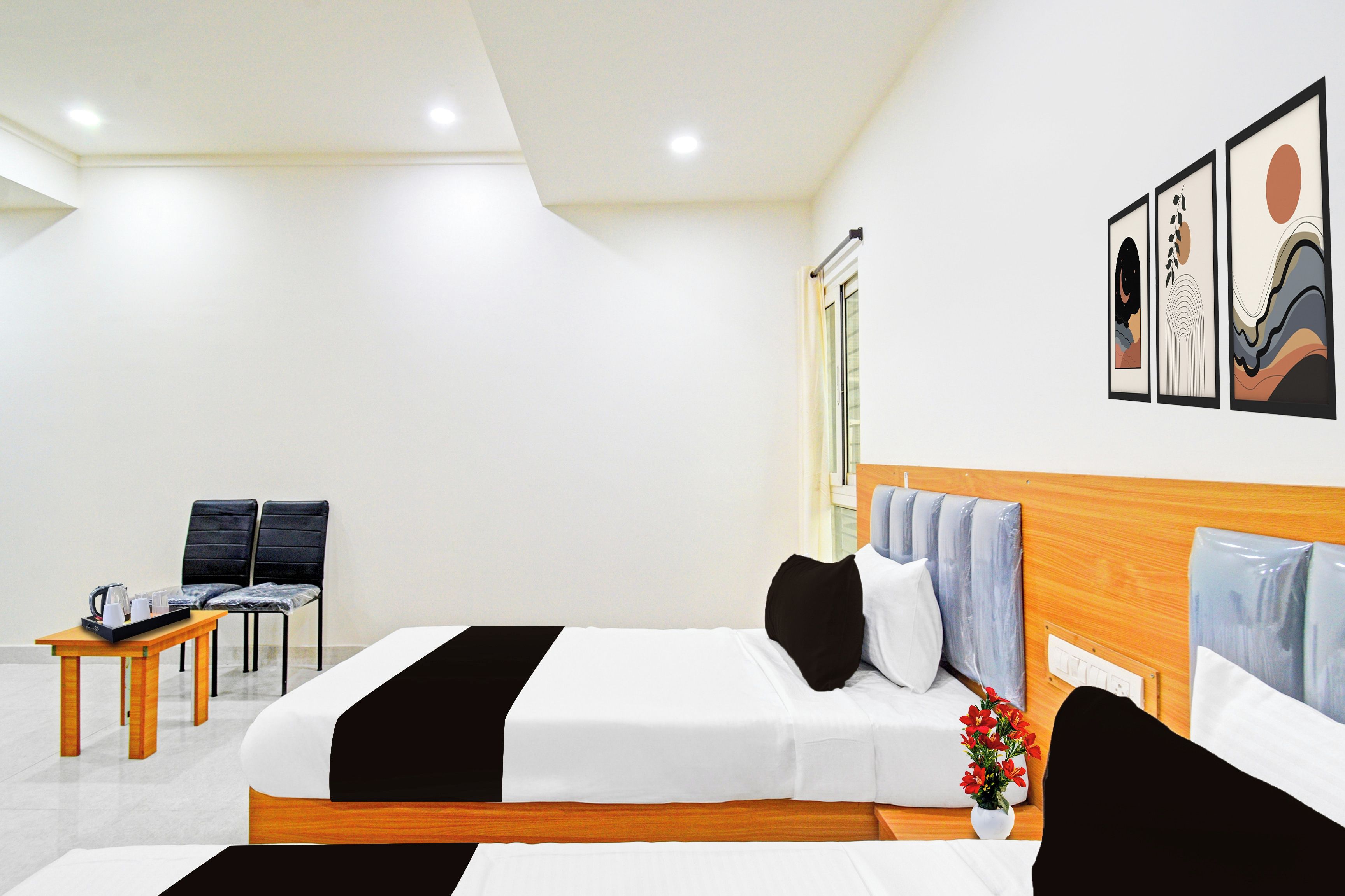 A hotel room with a bed, bedside tables, a chair, a small table with a tray, and a window.