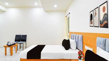 A hotel room with a bed, bedside tables, a chair, a small table with a tray, and a window.