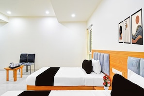 Habitación de hotel con cama, mesitas de noche, una silla, una mesita con bandeja y una ventana.