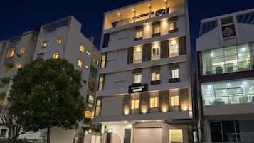 Um edifício de vários andares com uma placa indicando 'TOWNHOUSE' e uma entrada de garagem visível.