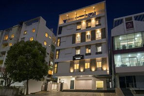 A multi-story building with a sign reading 'TOWNHOUSE' and a visible garage entrance. - Super Townhouse Alwal Road (Hyderabad)