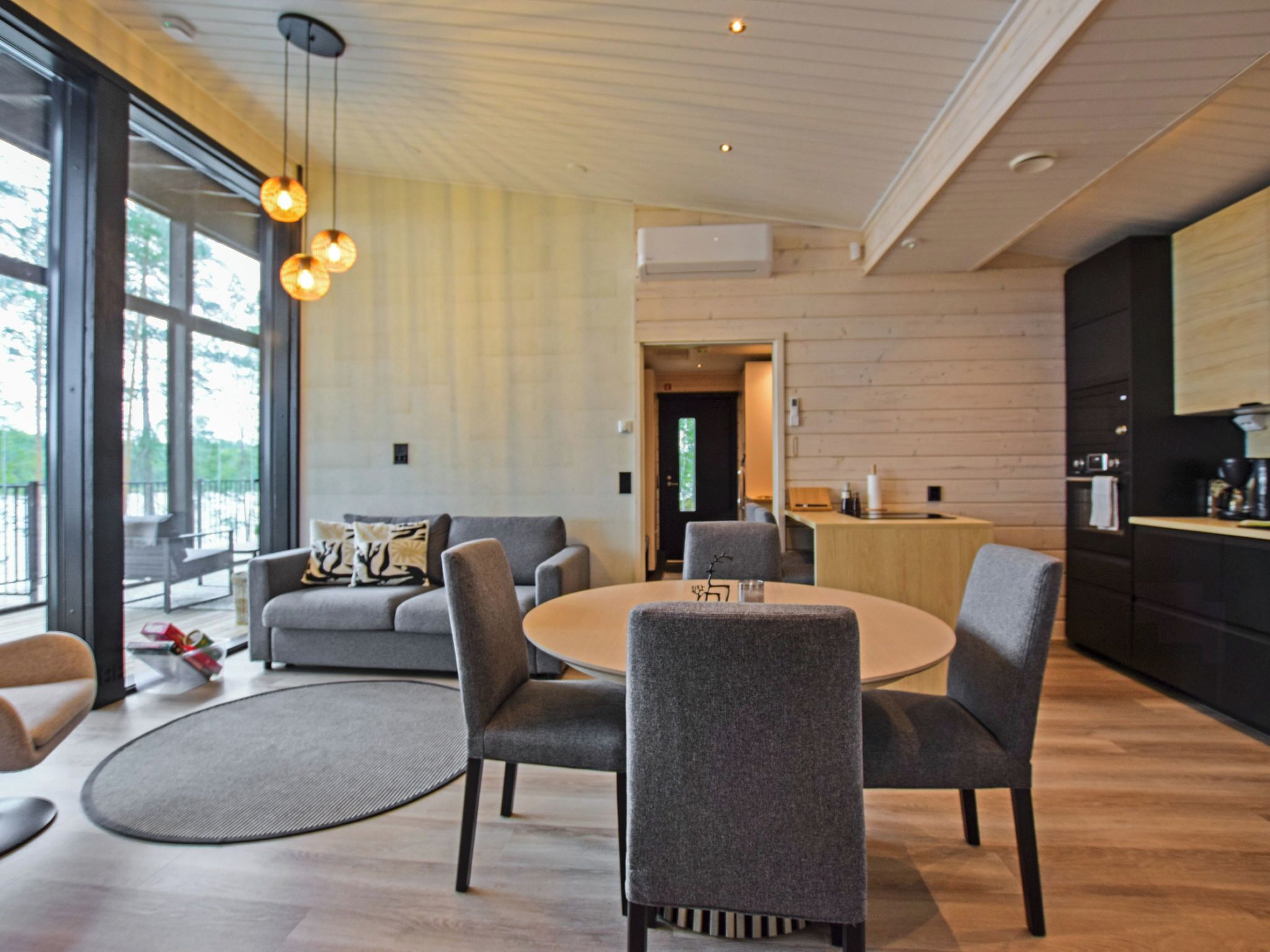 Un intérieur moderne comprenant un coin repas, des canapés et une cuisine.