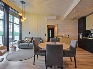 A modern interior with a dining area, sofas, and a kitchen.