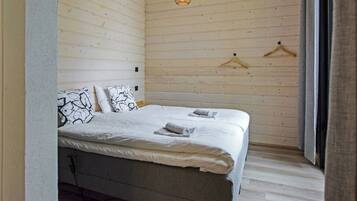 Une chambre à coucher avec un lit, des luminaires suspendus et un mur en bois.