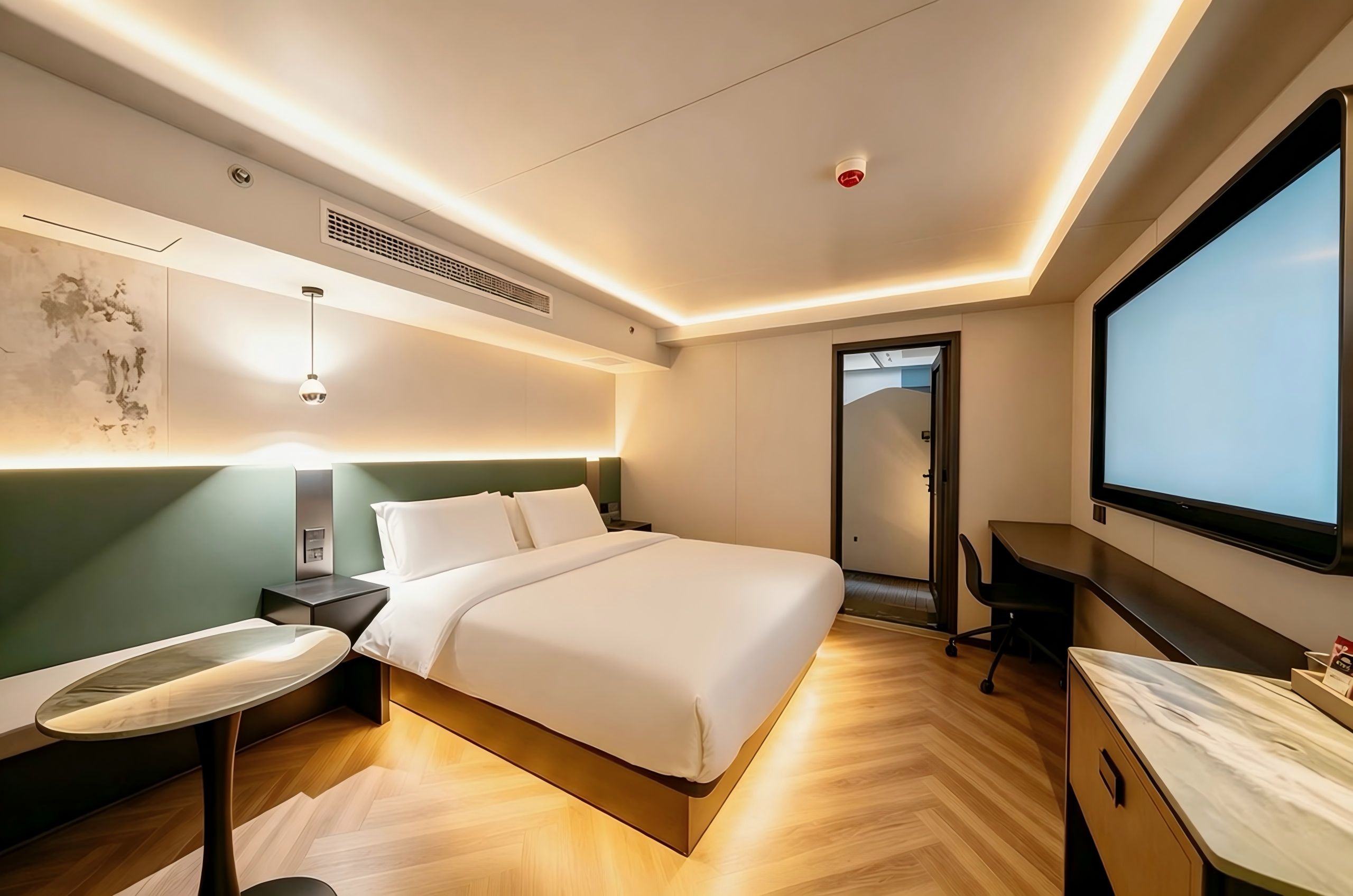 Une chambre d’hôtel moderne équipée d’un lit, d’un bureau, d’une chaise et d’une grande fenêtre.
