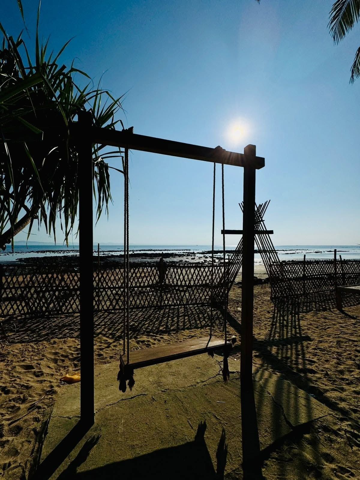 Une balançoire installée sur la plage, avec vue sur l’océan.
