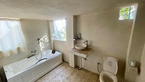 Un baño con bañera, lavabo e inodoro.