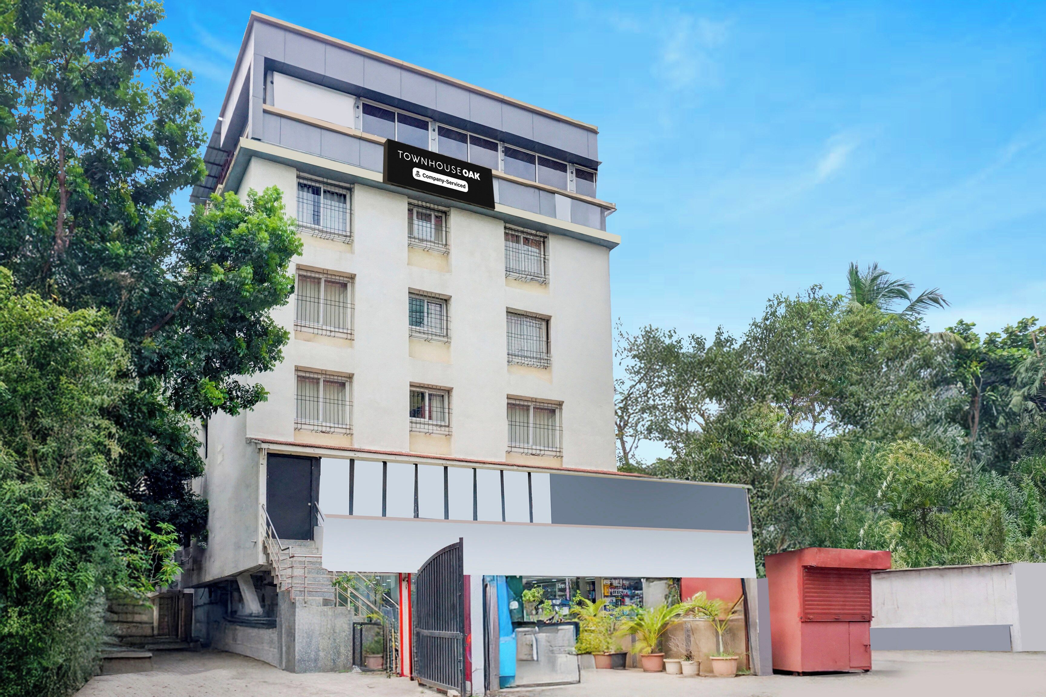 A multi-story building with a sign indicating it is a company-serviced townhouse.