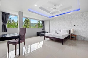 A modern hotel room with a bed, a desk, a chair, and a view of the outdoors. - Golf view, pool villa. 5 Bed/Bath. 7 kms to Patong. Peaceful & private (Tambon Kathu)