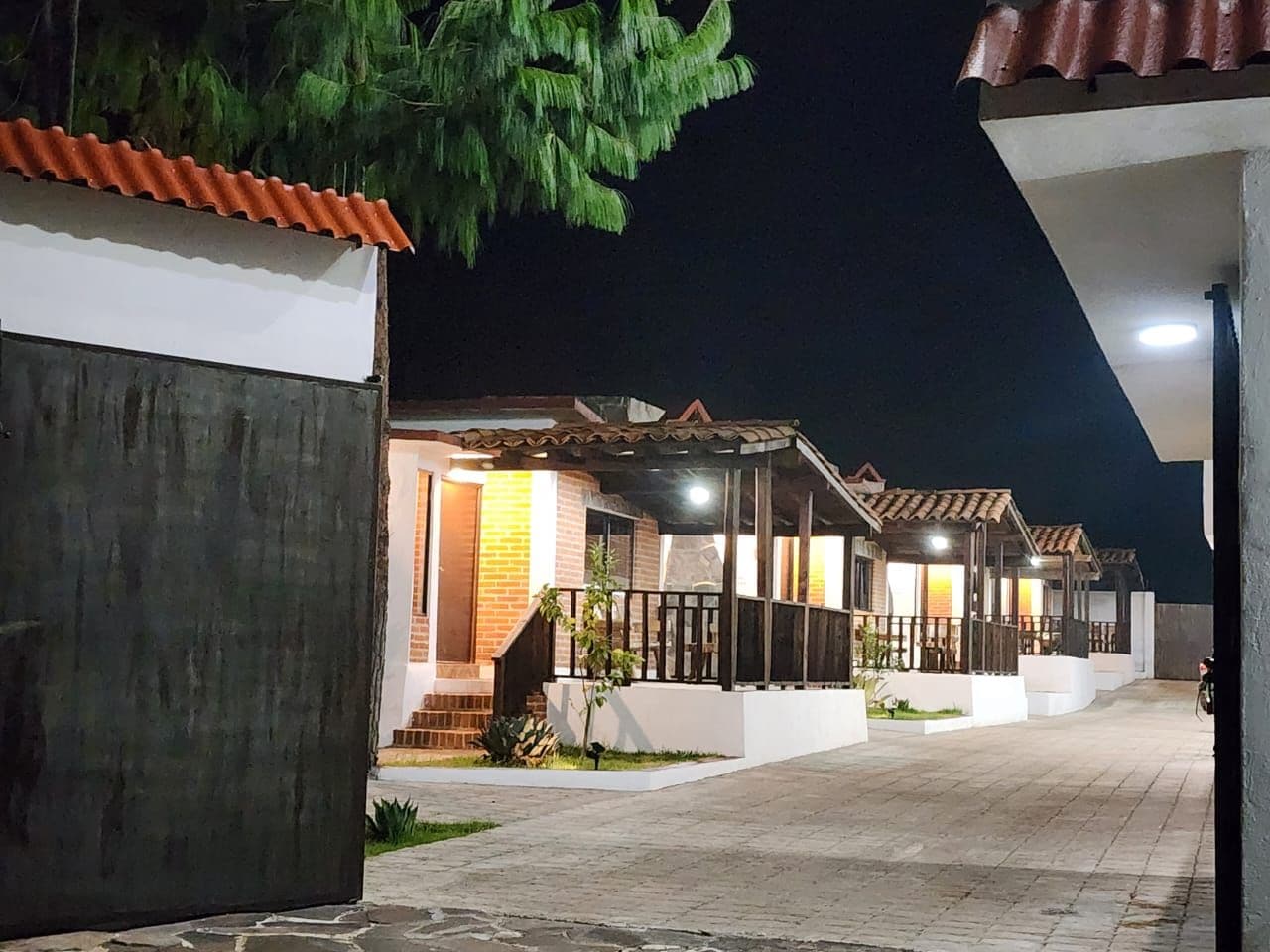 A row of residential buildings with a covered outdoor area, possibly a courtyard, and a paved walkway.
