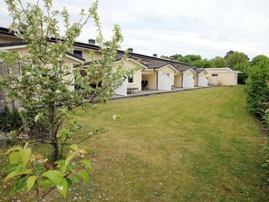 A residential property with a well-maintained lawn, a covered outdoor area, and a garden with flowering plants. - Seestern at Susanne-fischer Weg 25 (Wyk auf Foehr)