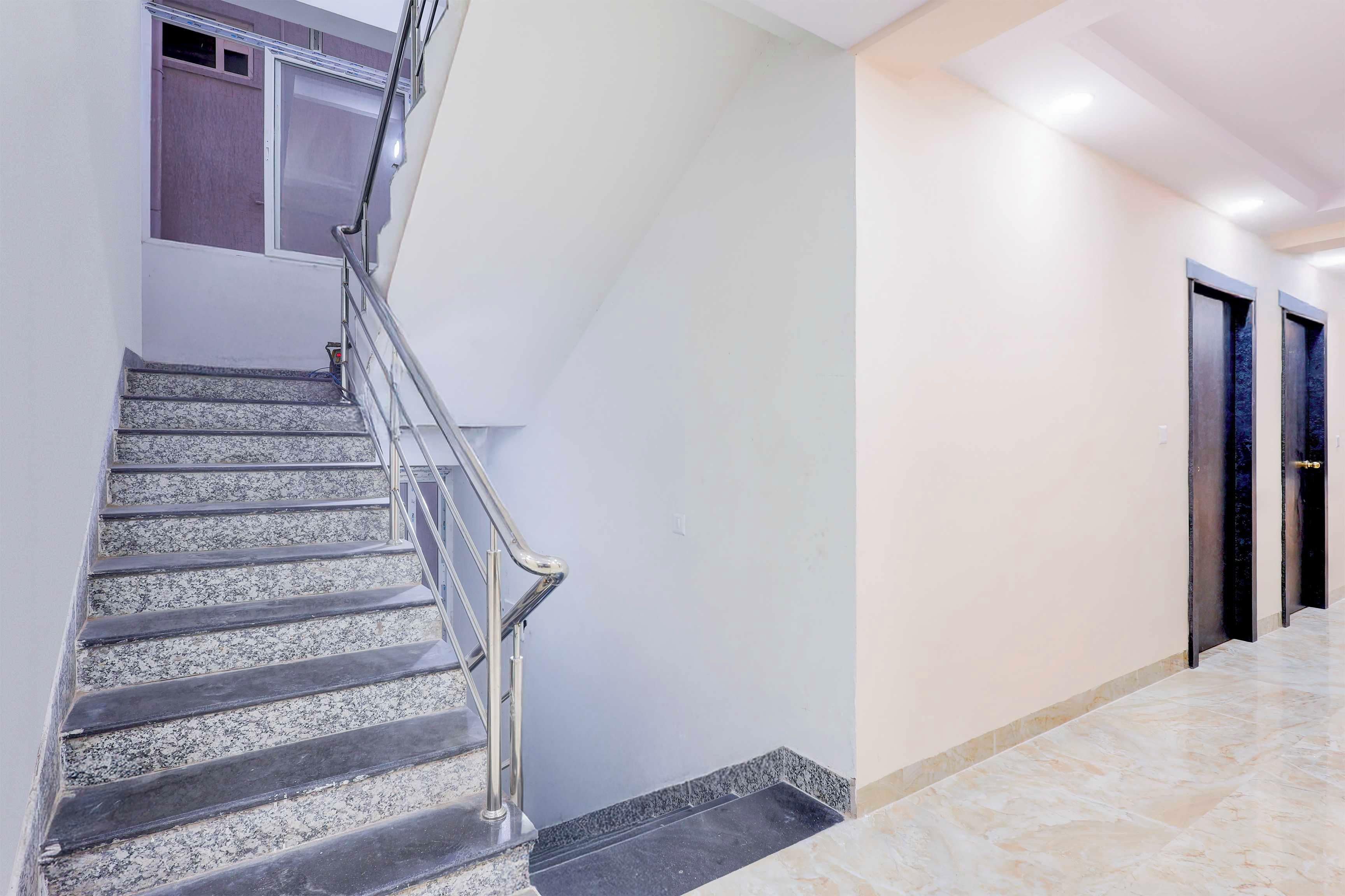 Un intérieur moderne avec un escalier en marbre, des rampes en métal et un design épuré et minimaliste.