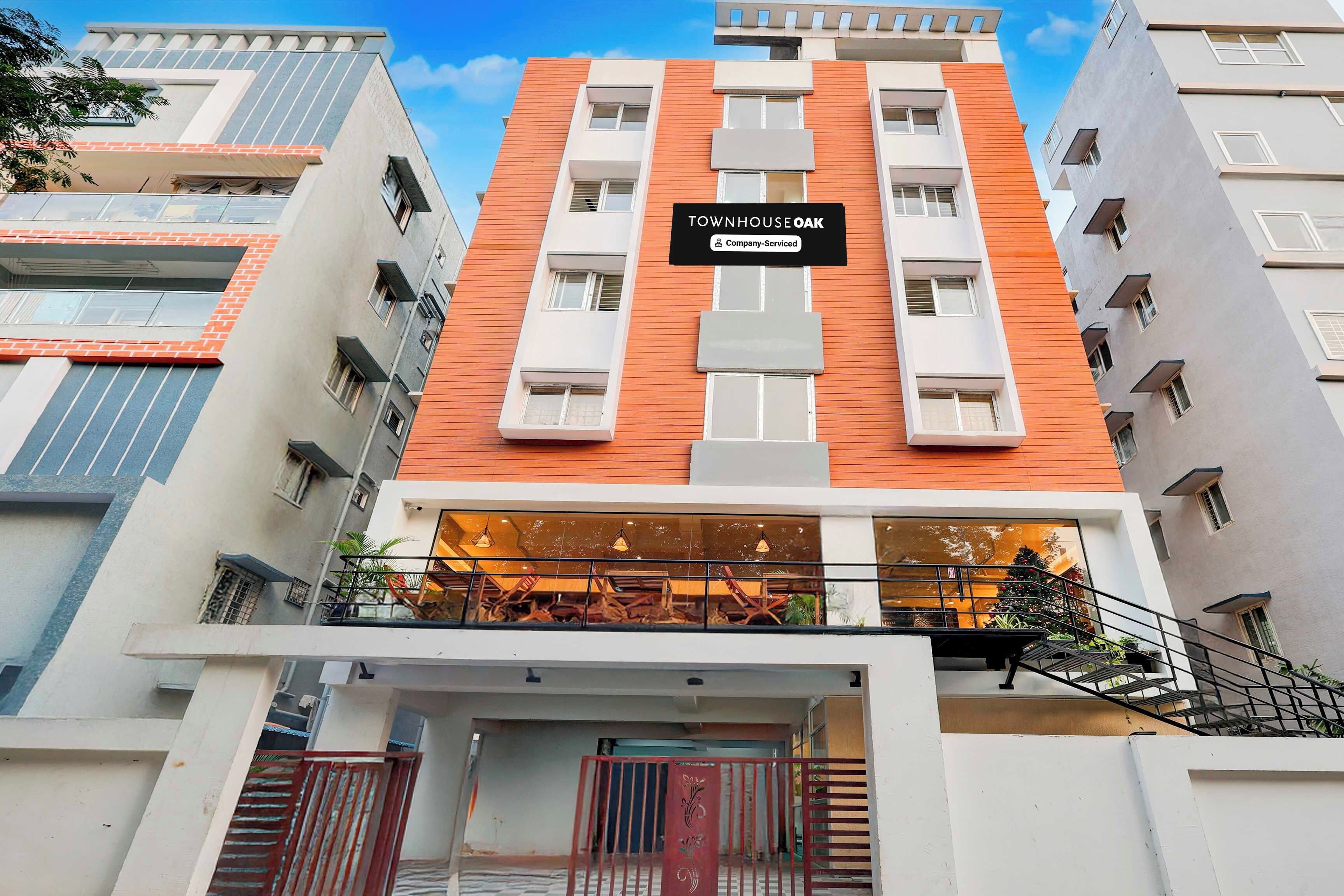 Un edificio de varios pisos con un letrero que dice 'TOWNHOUSE OAK Company Serviced'.
