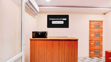 Un comptoir d’accueil avec une enseigne indiquant « TOWNHOUSE OAK » et « Services aux entreprises ».