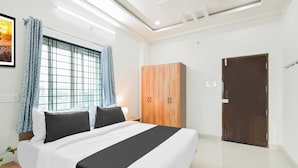 Et moderne hotelværelse med en stor seng, et skab og en dør.