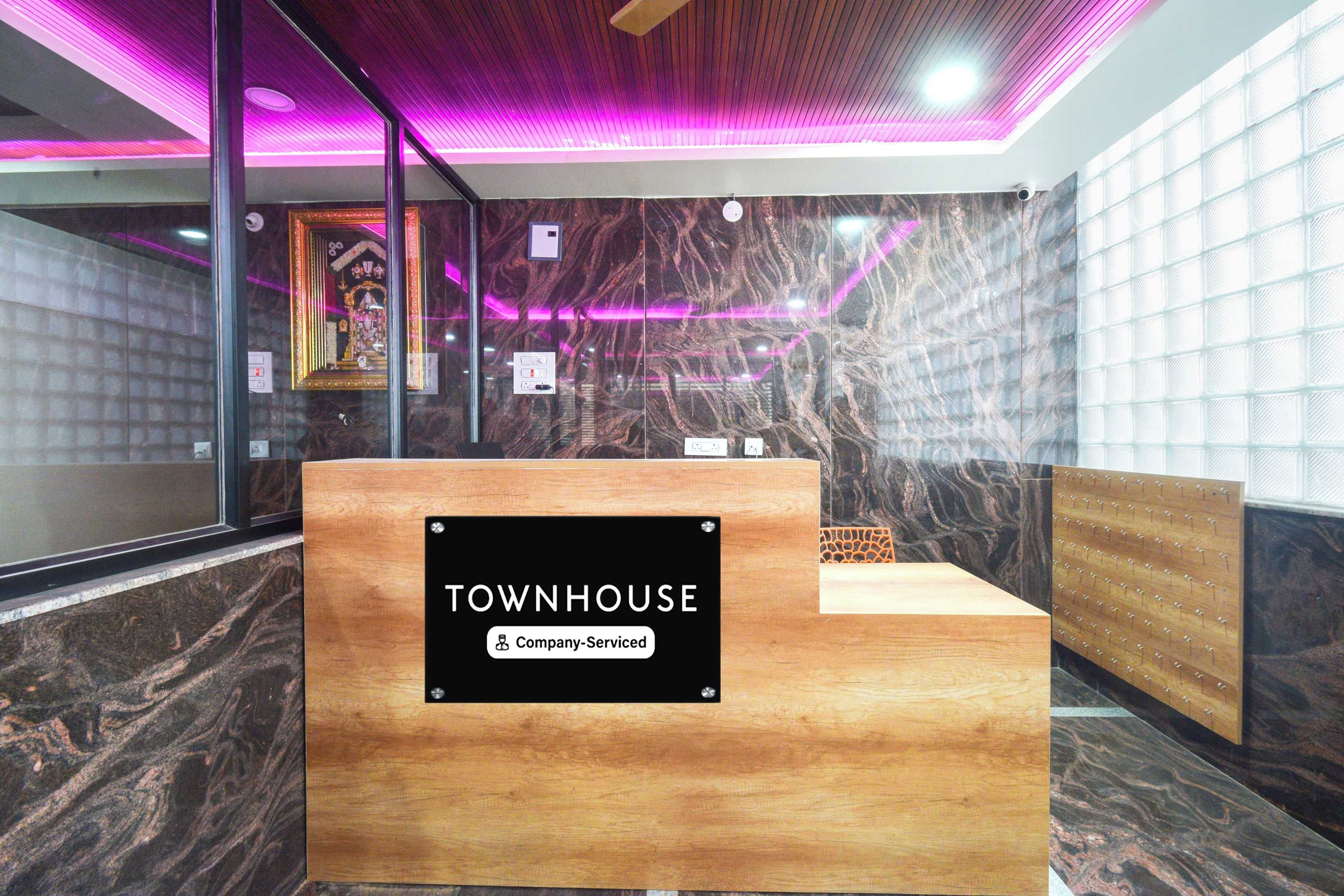 Uma mesa de recepção com uma placa indicando 'TOWNHOUSE Company Serviced'.