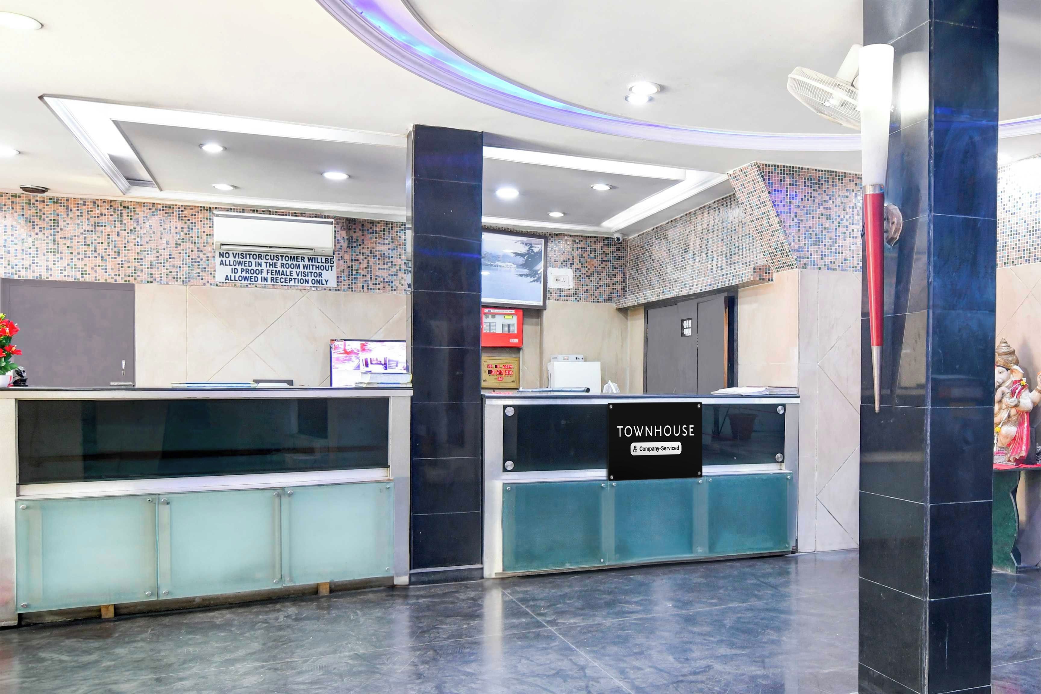 Zona de recepción con pantalla digital, cartel que indica servicio de la empresa y mostrador de recepción.