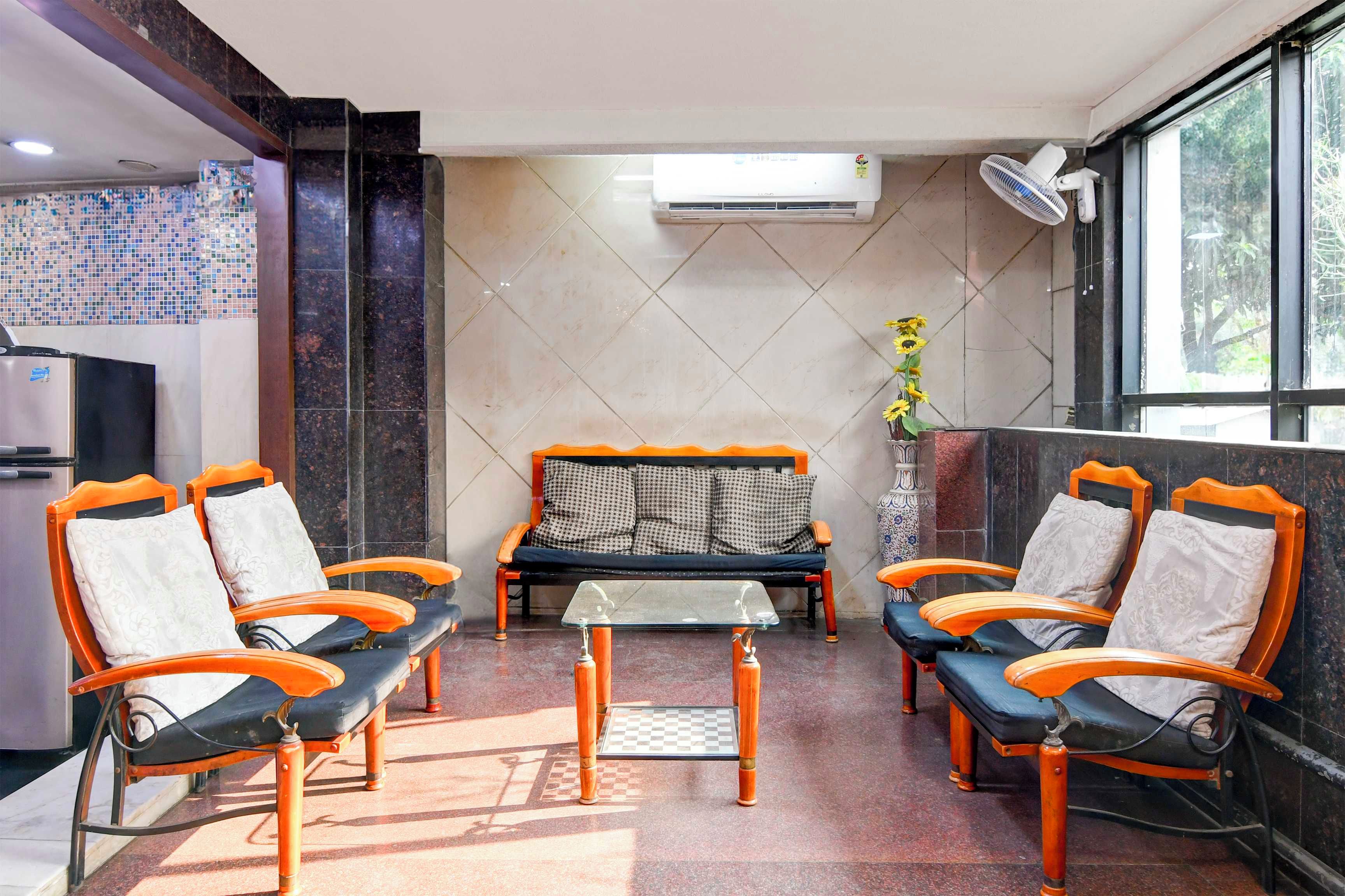 Habitación de hotel con sofá, una mesita y ventanal con vistas.