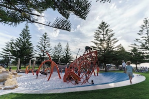 Ein Spielplatz mit Schaukeln, Rutschen und Klettergeräten.