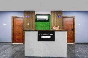 Un mostrador de recepción con un letrero que indica 'TOWNHOUSE OAK' y 'Servicio de empresa'.