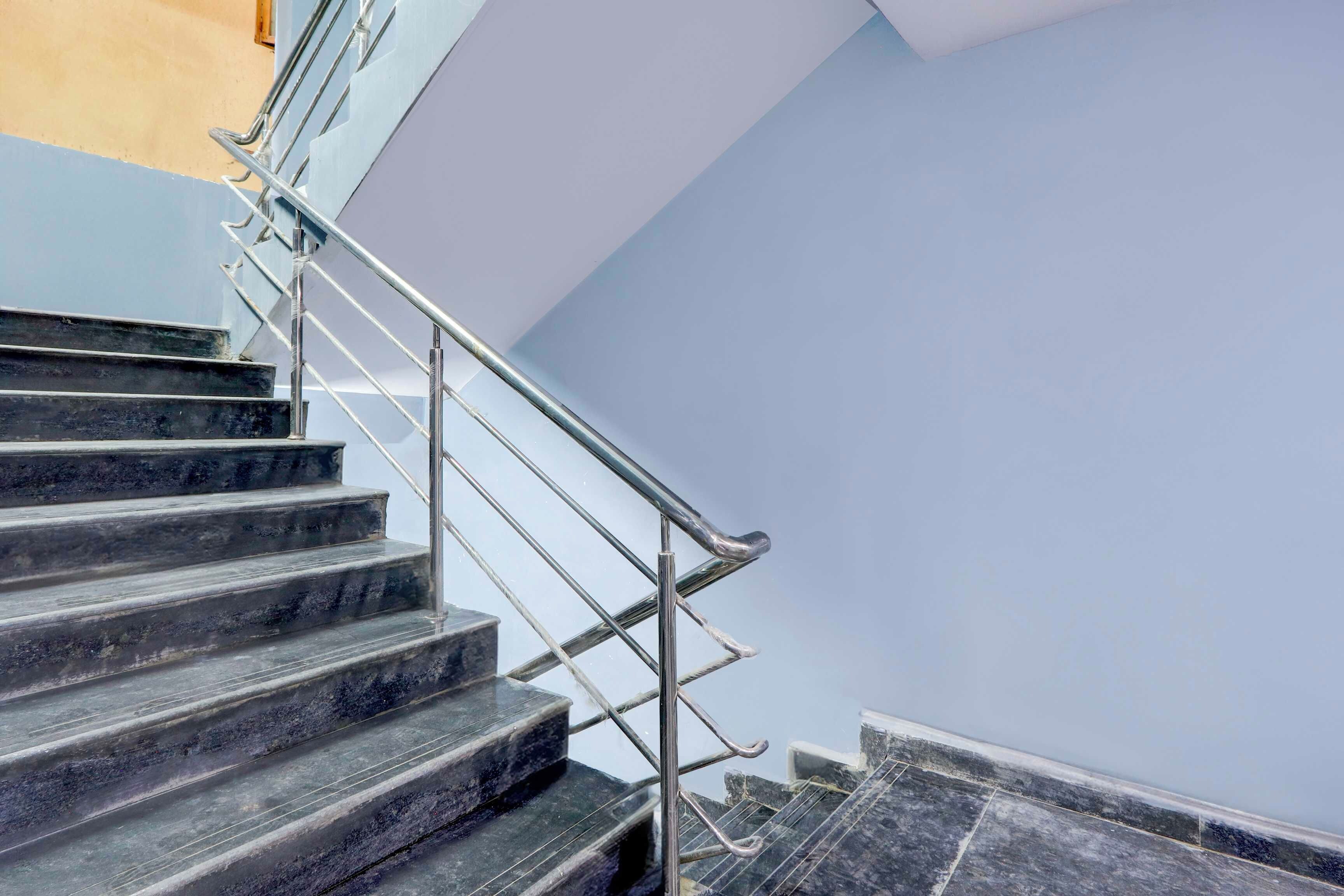Una escalera con barandillas de metal y peldaños oscuros.