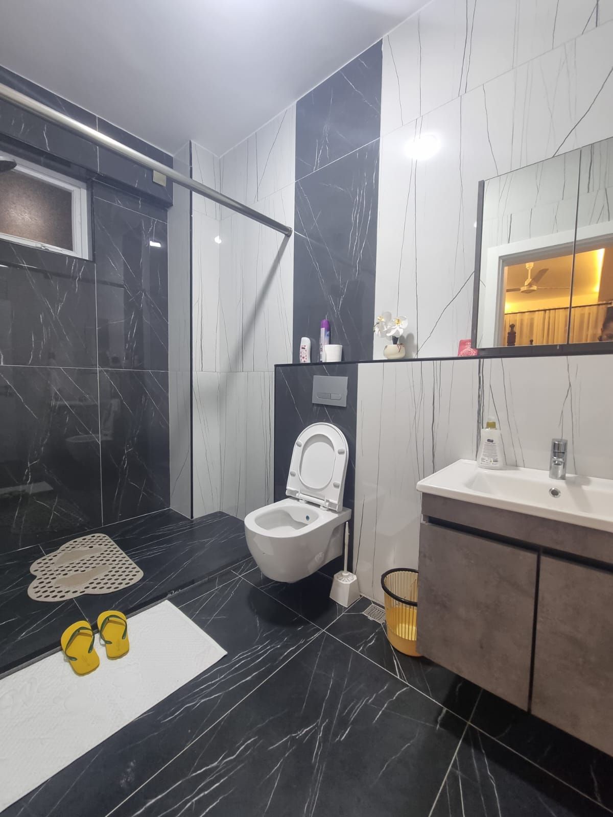 Ein modernes Badezimmer mit Toilette, Waschbecken und Duschbereich.