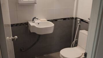 A small bathroom with a toilet, sink, and mirror.