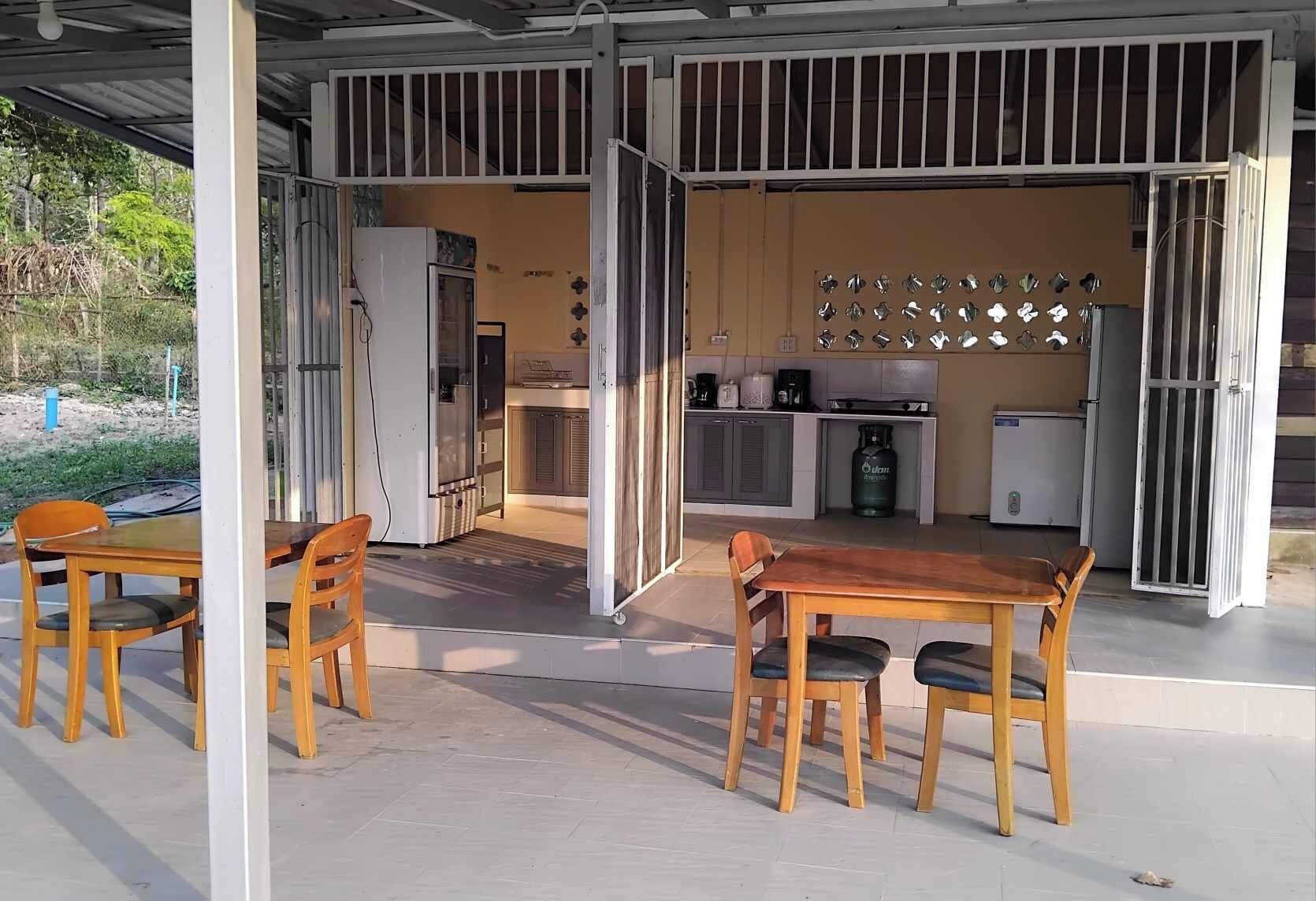 An open-plan living area with a kitchen, dining table, and chairs.