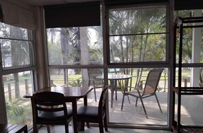 Una habitación con un ventanal grande, una mesa y sillas.