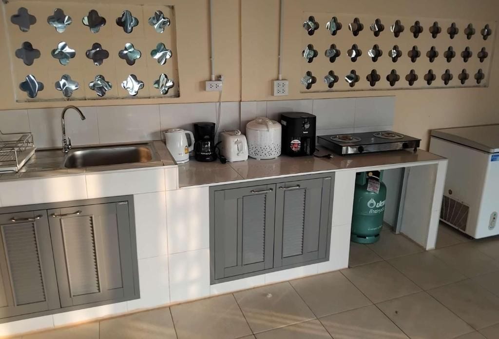 Een keuken met een roestvrijstalen spoelbak, een koffiezetapparaat, een broodrooster en een gasfornuis.