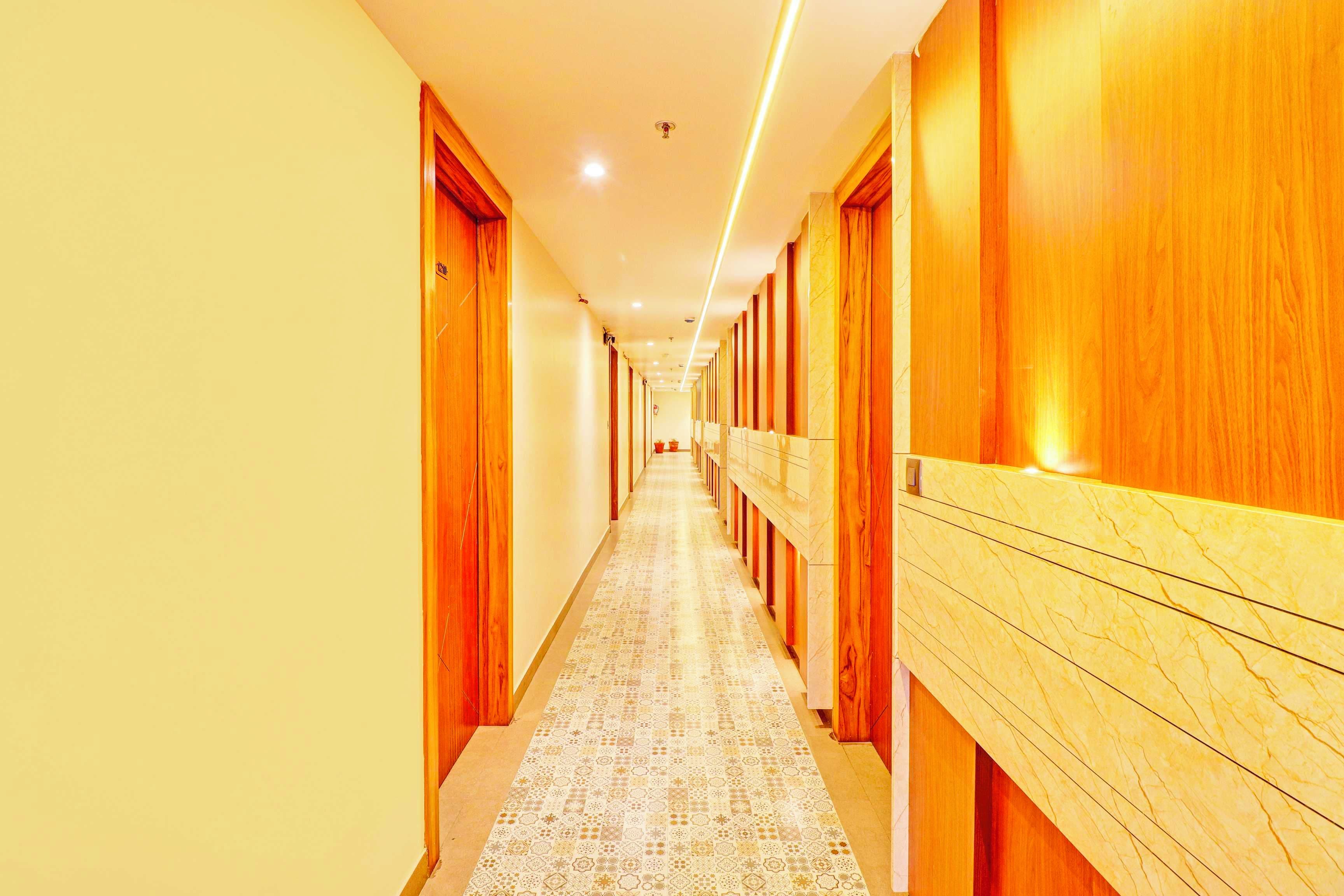 A hotel corridor with wooden doors and a patterned floor.
