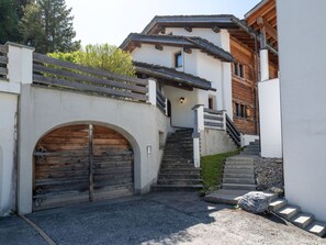 Ein Gebäude mit Holztür, Treppe und Steinmauer.