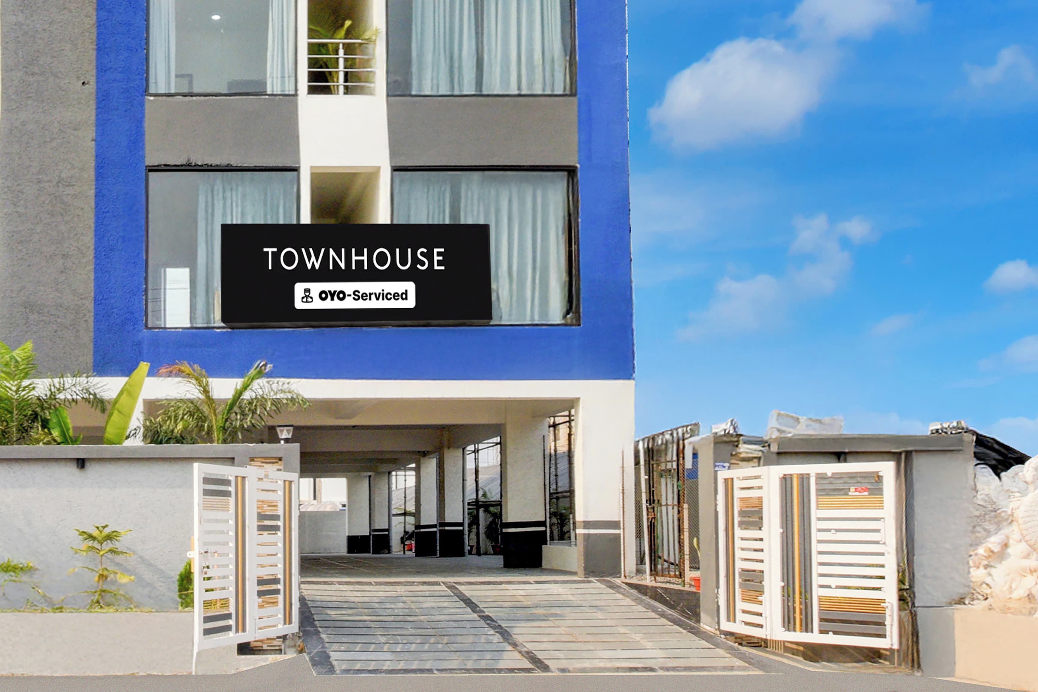A modern townhouse with a sign indicating it is serviced by OYO.