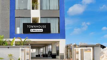 A modern townhouse with a sign indicating it is serviced by OYO.