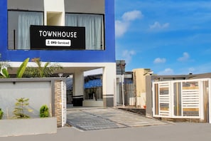 A modern townhouse with a sign indicating it is serviced by OYO.